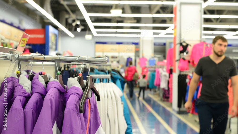 Interior of clothing store and going customers Interior of clothing store and going customers