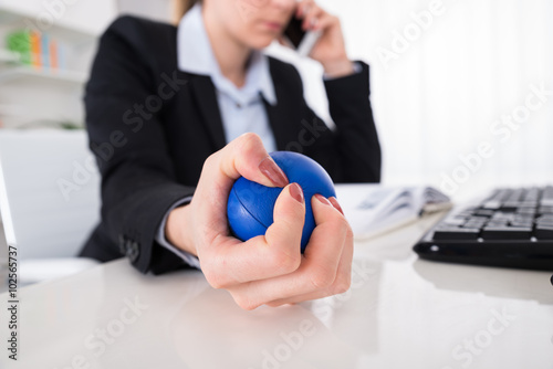 Businesswoman Pressing Stressball At Desk photo