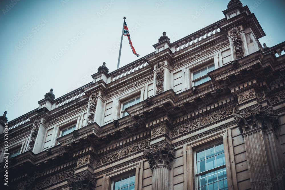 Fototapeta premium Old classical building with waving flag