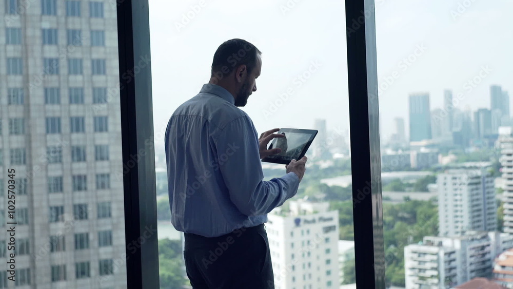 Young businessman using tablet computer in office by window
Young businessman using tablet computer in office by window