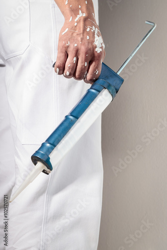 Workman Hand holding Caulking Gun for Silicone Sealant