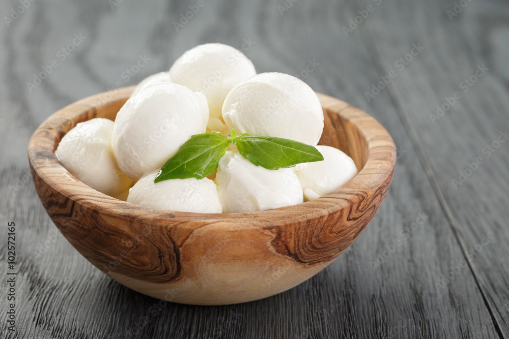 small balls of mozzarella in olive bowl with basil small balls of mozzarella in olive bowl with basil
