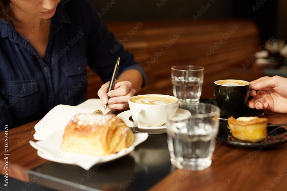 Two people having coffee and pastry at a cafe Two people having coffee and pastry at a cafe