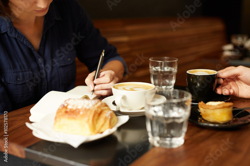 Two people having coffee and pastry at a cafe