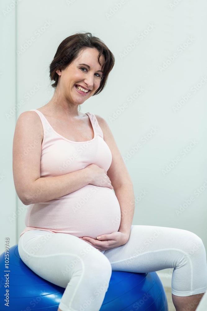 Pregnant woman sitting on exercise ball Pregnant woman sitting on exercise ball
