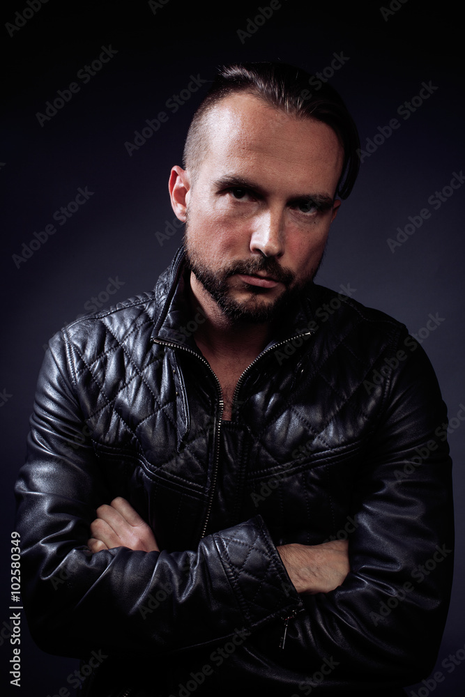 Fototapeta premium A man with tattooes on his arms. Silhouette of muscular body. caucasian brutal hipster guy with modern haircut, looking like criminal