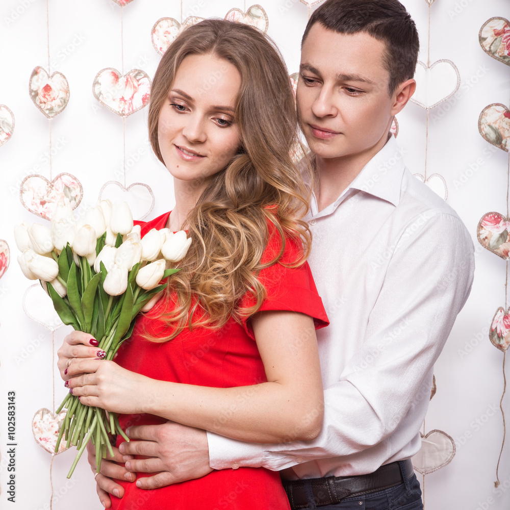 Beautiful young couple in love with a bouquet of flowers. Valentine's Day. Beautiful young couple in love with a bouquet of flowers. Valentine's Day.