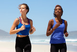 Two beautiful female runners exercising on the beach