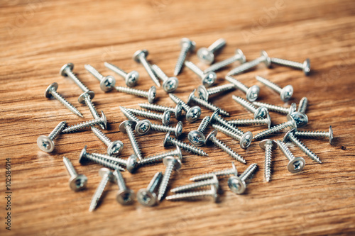 screws fasteners hardware on wooden background