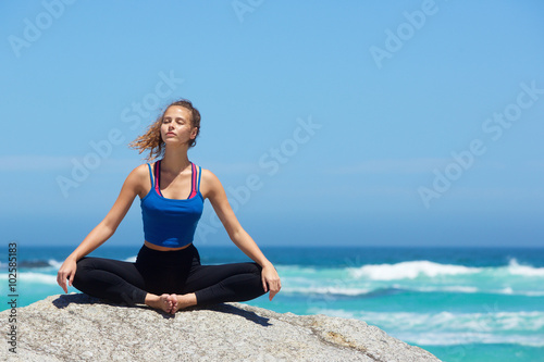 Yoga woman sitting alone by the sea