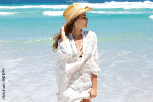 Beautiful young woman with hat at the beach
