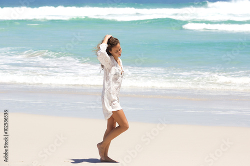 Young woman in contemplation walking on the beach