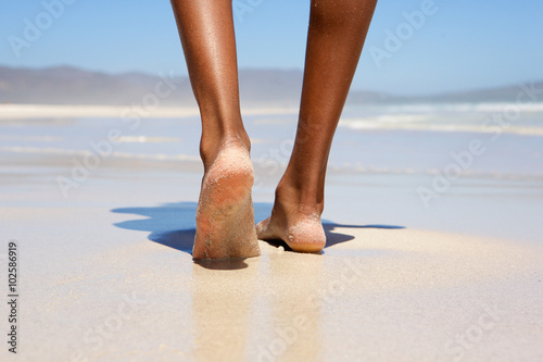 Woman walking barefoot on beach
