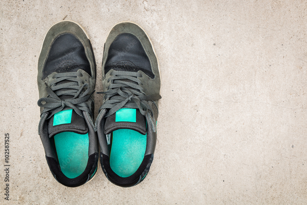Green suede sneakers for men on cement background. Wearing for travel and adventure. Top view.