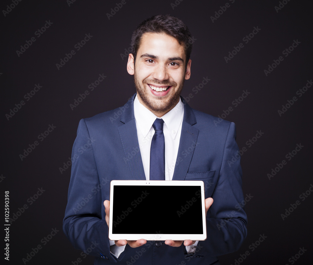 Businessman displaying a tablet computer on black background Businessman displaying a tablet computer on black background