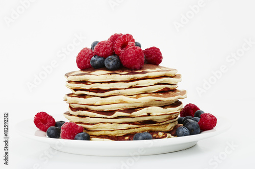 Fresh pancakes topped with fruit, studio shot