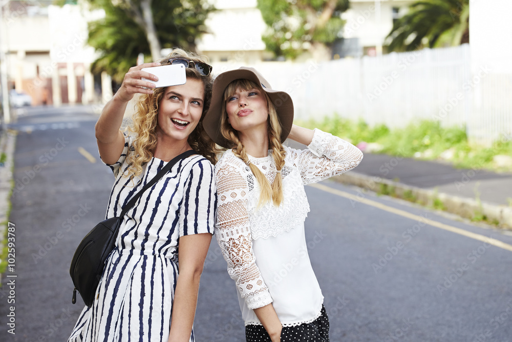 Young girlfriends posing for selfie, smiling