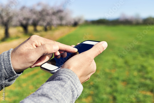 man using a smartphone in a natural landscape
