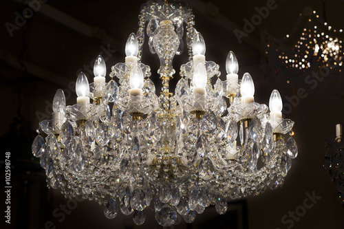 Brass chandelier with crystal. Lighted chandelier with crystal pendants.