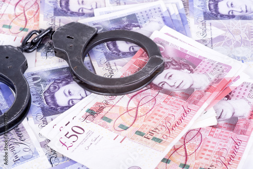 Crime and Money. Handcuffs are on the pounds