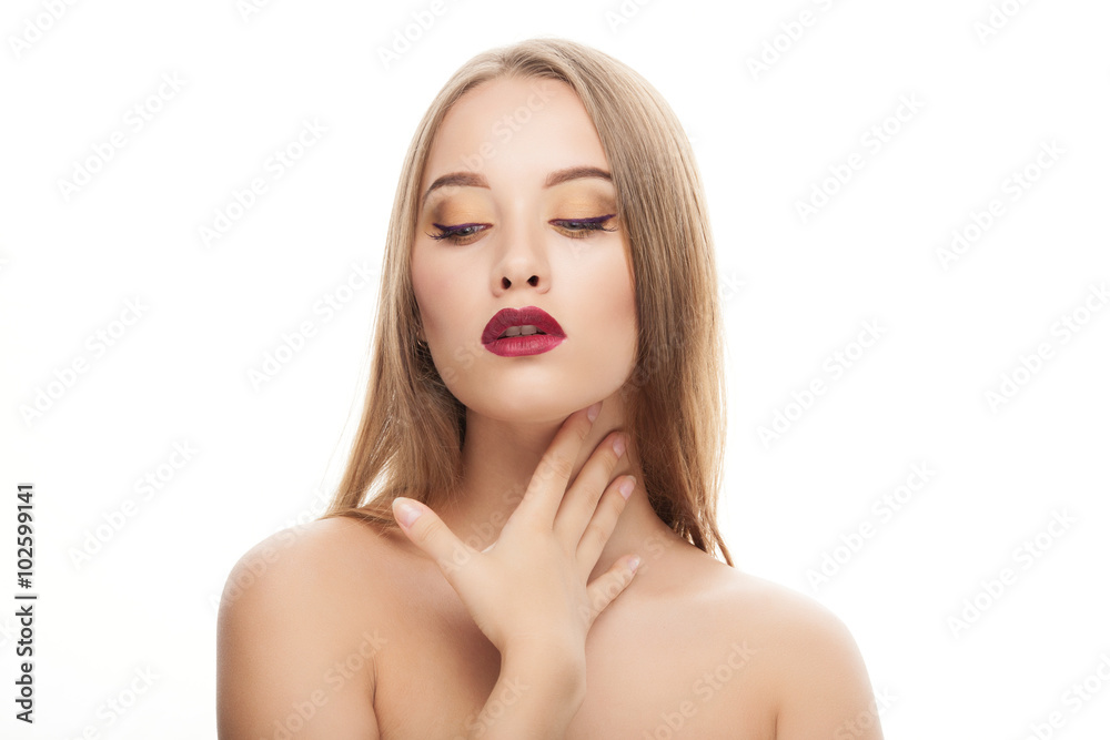 Closeup portrait of young elegant blonde woman with gorgeous fashionable makeup posing with half closed eyes and bare shoulders on white studio background touching her neck Closeup portrait of young elegant blonde woman with gorgeous fashionable makeup posing with half closed eyes and bare shoulders on white studio background touching her neck