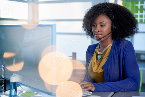 Canvas Print Portrait of a smiling customer service representative with an afro at the comput