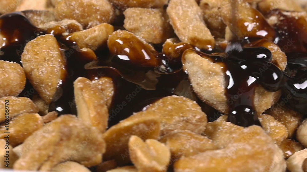 Pouring delicious chocolate syrup over mixed nuts Pouring delicious chocolate syrup over mixed nuts