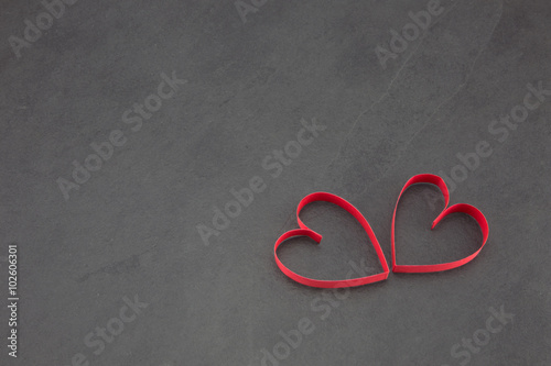Two red hearts on a slate background 