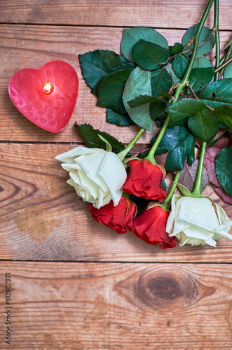 Fototapeta Naklejka Na Ścianę i Meble -  bunch of red roses with red candle on wooden background