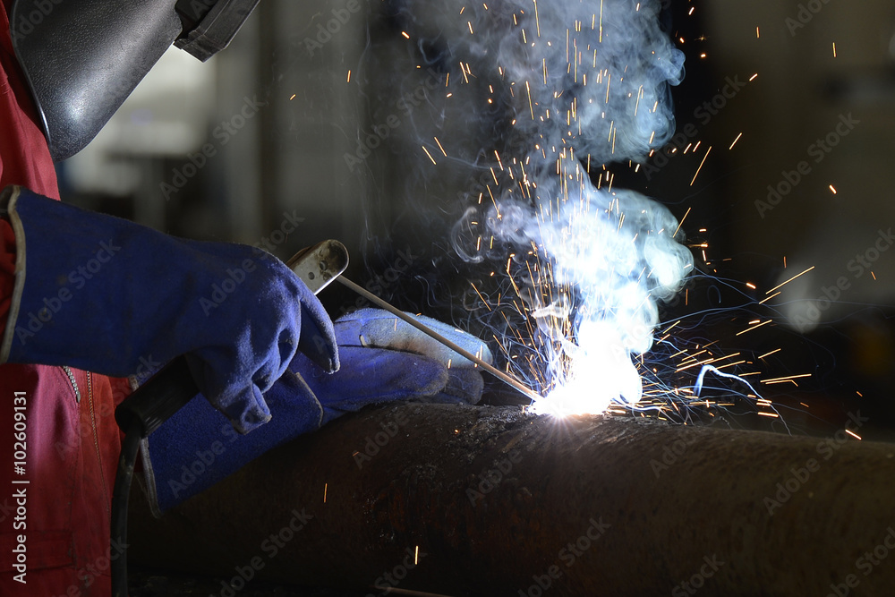 Worker during use electric wheel grinding on steel structure in factory work shop. Worker during use electric wheel grinding on steel structure in factory work shop.