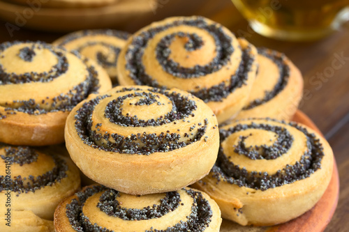 Homemade poppy seed rolls piled on a plate, photographed with natural light (Selective Focus, Focus one third into the roll in the front)