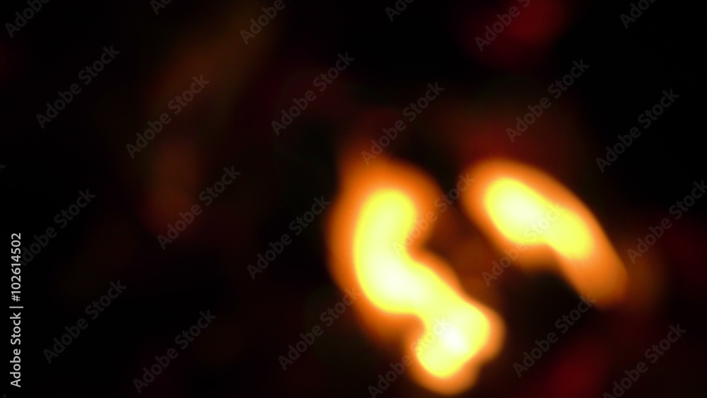 Captivating slow motion shot of a mesmerizing wood fire,where enchanting flames gracefully dance in an out of focus display.