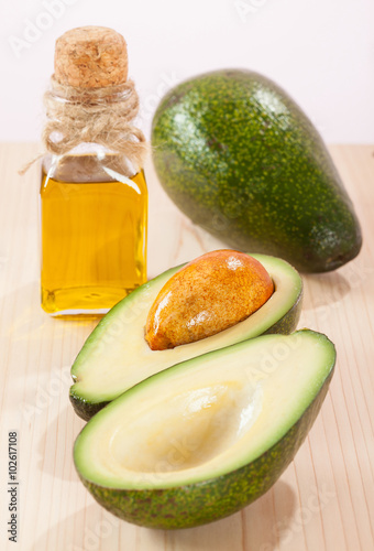Fresh avocado and a bottle of oil
