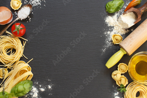 Fresh pasta and ingredients on a dark board