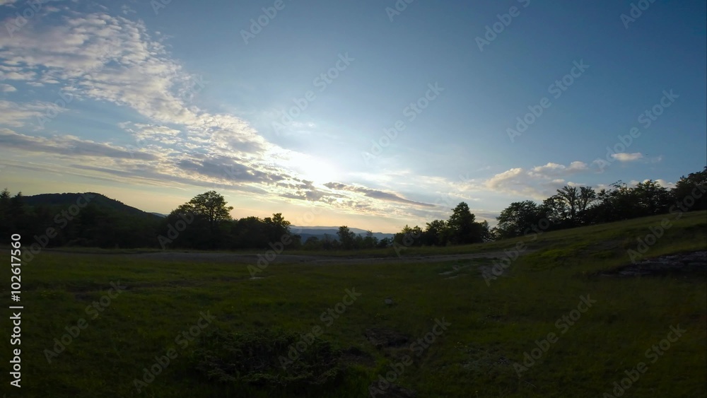 Clouds quickly swim over a grassy field in the mountains, obscuring its Clouds quickly swim over a grassy field in the mountains, obscuring its