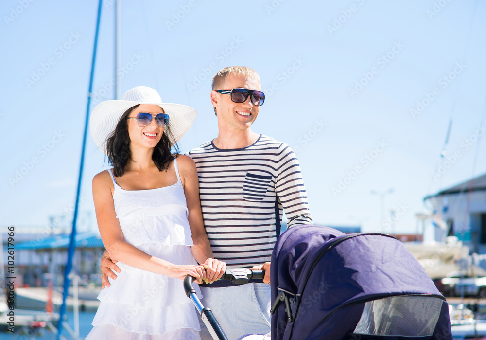 Young and attractive couple walking with a baby pram outdoor