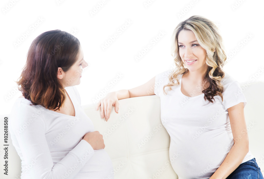 Two young beautiful pregnant women on a sofa Two young beautiful pregnant women on a sofa