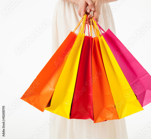 Happy young woman with multicolored shopping bags