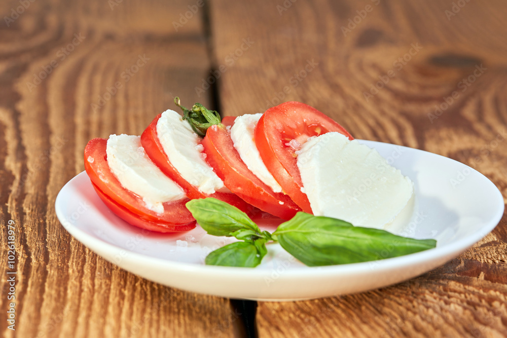 Brown wooden table with caprese salad Brown wooden table with caprese salad