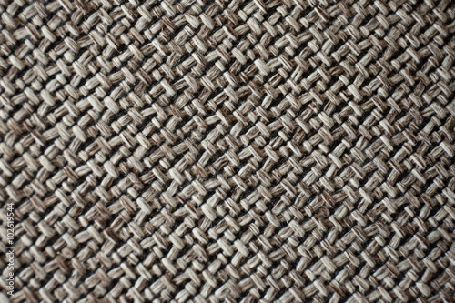 A macro image of a repetitive pattern created by the texture of woven fabric.