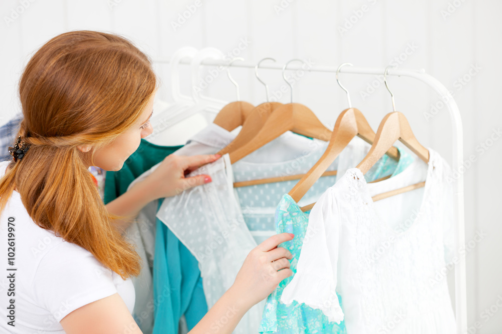 Fototapeta premium woman chooses clothes in her wardrobe