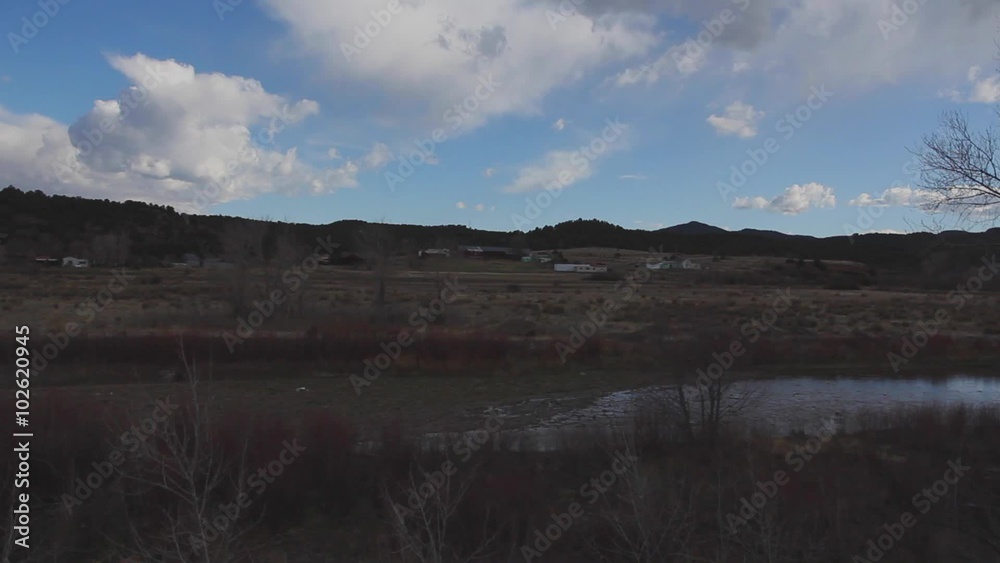 Tilt from sky to a stream and farm land. Tilt from sky to a stream and farm land.