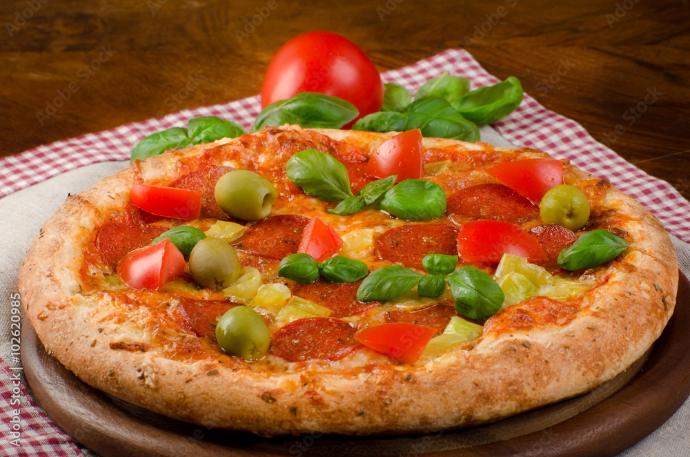 homemade pizza with salami, pepperoni, Basil and tomatoes homemade pizza with salami, pepperoni, Basil and tomatoes