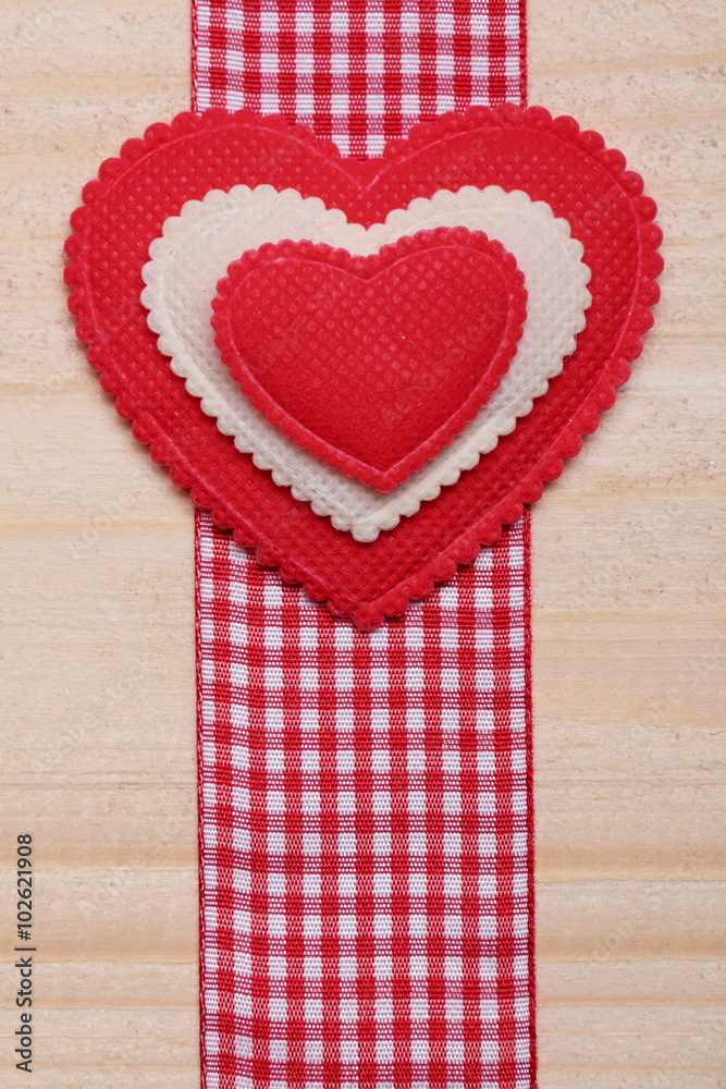 Decorative heart. / Red and white heart on a wooden background. Decorative ribbon red-white color. Decorative heart. / Red and white heart on a wooden background. Decorative ribbon red-white color.