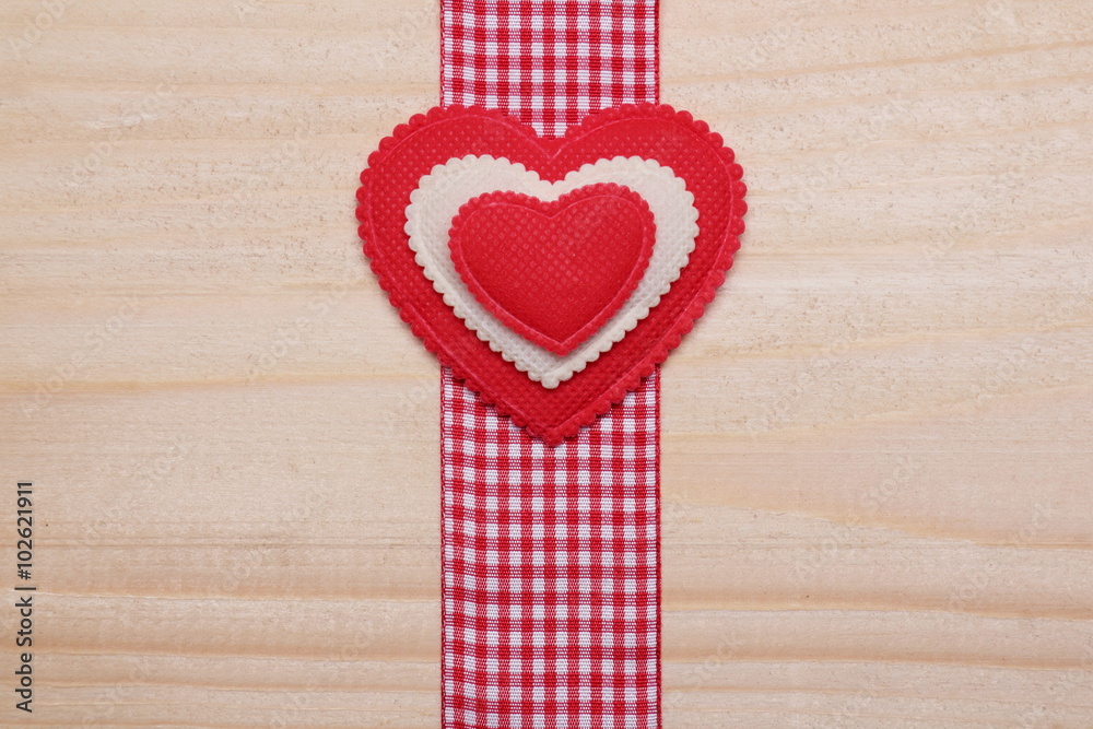 Obraz premium Decorative heart. / Red and white heart on a wooden background. Decorative ribbon red-white color.
