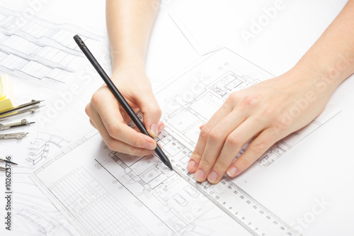 Architect working on blueprint. Architects workplace - architectural project, blueprints, ruler, calculator, laptop and divider compass. Construction concept. Engineering tools