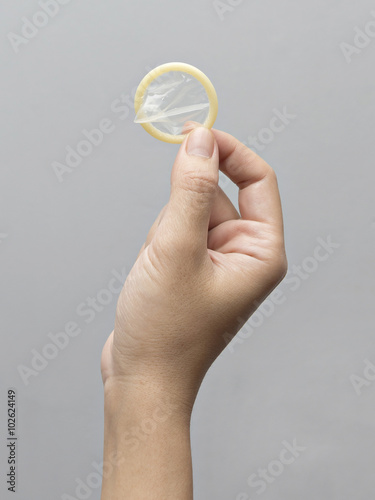 Female hand holding condom