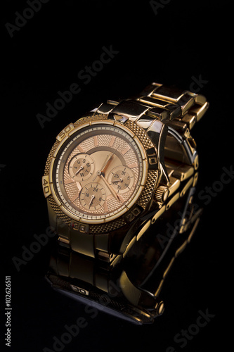 Gold watch on a plastic background