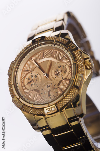 Gold watch on a plastic background