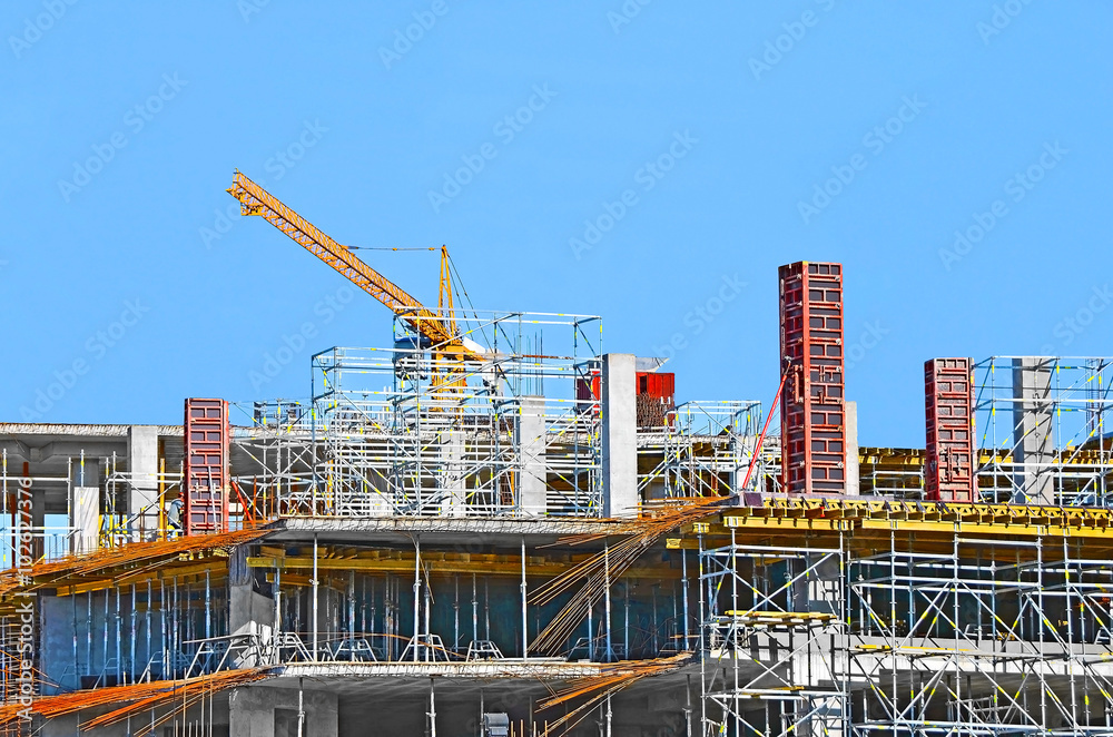 Building crane and building under construction against blue sky Building crane and building under construction against blue sky
